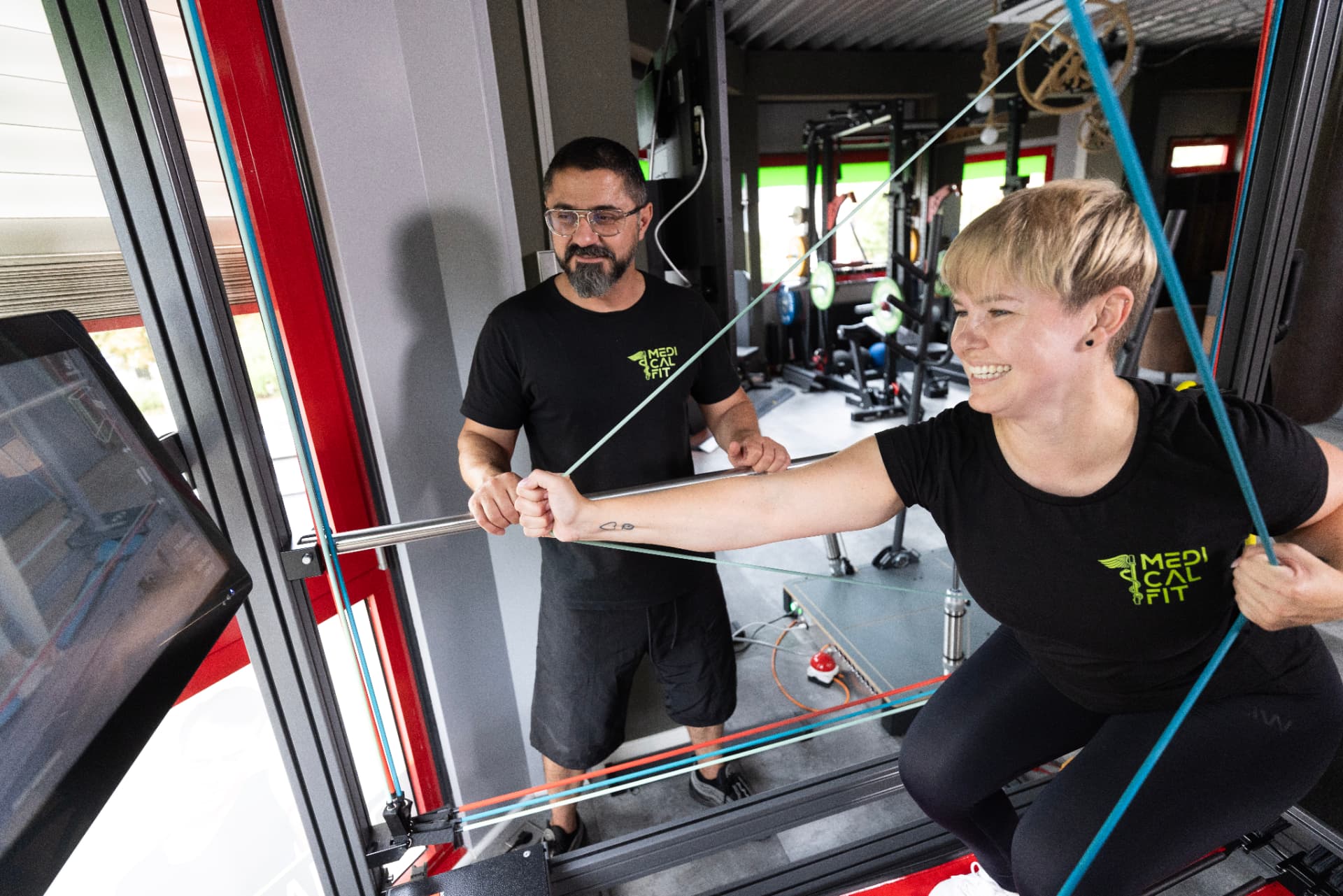 Trainer und Klientin am Trainingsgerät